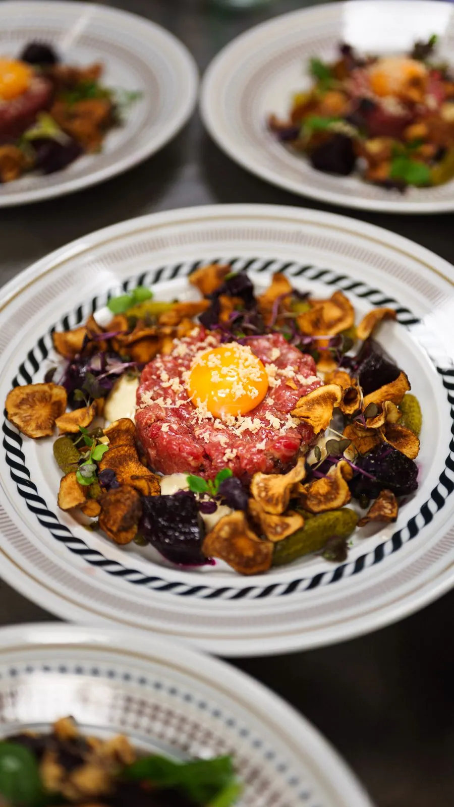 Råbiff med äggula, riven pepparrot, jordärtskockschips, bakade betor och cornichoner på Bierhuis